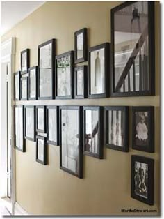 a wall with many framed pictures on it