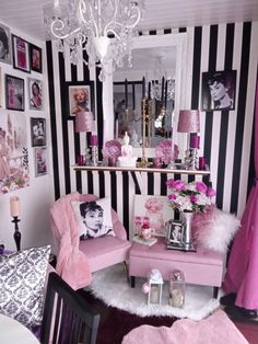 a living room with black and white stripes on the walls, pink furniture and decor