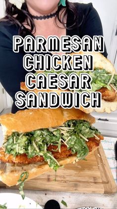 a woman holding two chicken caesar sandwiches with lettuce and tomato on them, in front of the words parmesan chicken caesar sandwich sandwhich