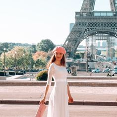 a woman is standing in front of the eiffel tower