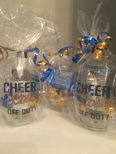 three clear glass jars with blue ribbon and cheer on them