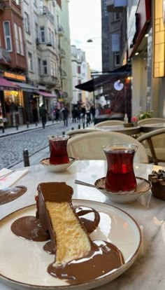 a piece of cake sitting on top of a white plate next to a cup of coffee