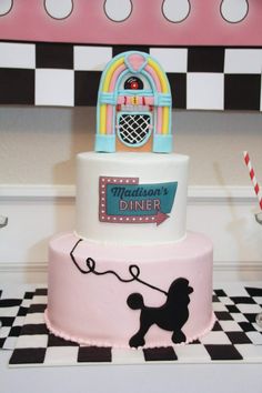 a three tiered cake is decorated with an image of a poodle on it