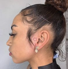 a close up of a person with ear piercings on their ears and wearing a black shirt