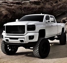 a white truck parked in front of some rocks