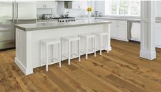 a kitchen with white cabinets and wooden floors