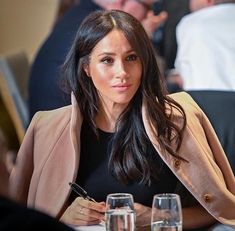 a woman sitting at a table with wine glasses