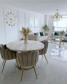 a living room filled with furniture and a white marble dining table surrounded by beige chairs