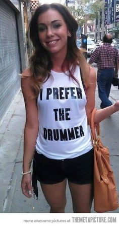 a woman is walking down the street with her hand in her pocket and wearing a t - shirt that says i prefer the drummer