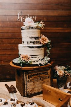 a three tiered cake sitting on top of a table next to other desserts