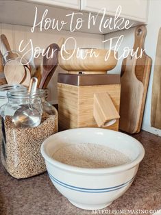 a white bowl sitting on top of a counter next to wooden spoons and measuring cups