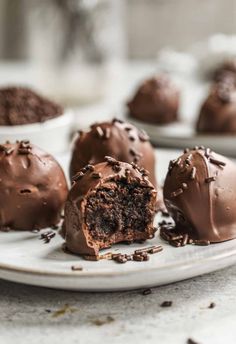 three chocolate truffles on a plate with one cut in half