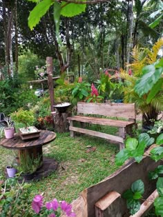 a wooden bench sitting in the middle of a lush green park filled with flowers and trees