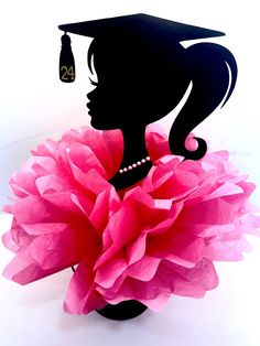 a silhouette of a woman wearing a graduation hat and holding a large pink flower