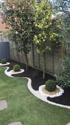 a garden area with grass, rocks and trees