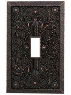 an ornate metal switch plate with a decorative design on the front and back cover,