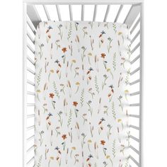 a white crib with flowers and leaves on the side, in front of a white background