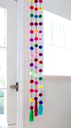 the door is decorated with colorful pom - poms hanging from it's side