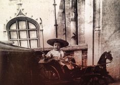 an old photo of a child in a horse drawn carriage