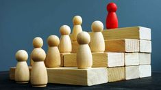 a group of wooden figures standing on top of each other in front of a stack of blocks