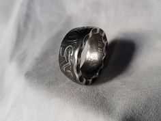 a silver ring sitting on top of a white sheet