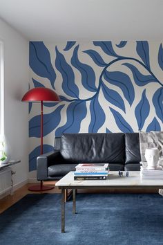 a living room with blue and white wallpaper on the walls, leather couches and coffee table