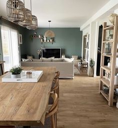 a living room filled with furniture and a wooden dining table in front of a tv