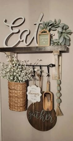 a shelf with some flowers and other items hanging on it's sides, along with a sign that says eat