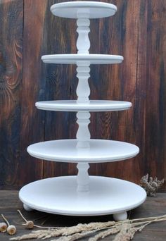 three tiered cake stand on top of a wooden table