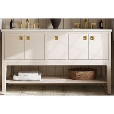 a bathroom vanity with two sinks and gold faucets on the wall above it