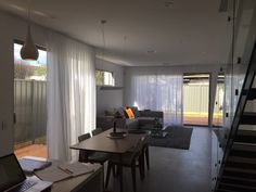 a living room filled with furniture and a laptop computer on top of a wooden table