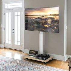 a flat screen tv mounted to the side of a wall in a living room next to a door