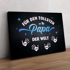 a sign that says fur den tolsten papa der welt with hand prints on it