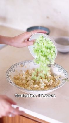 a person scooping celery out of a bowl onto a plate on a counter