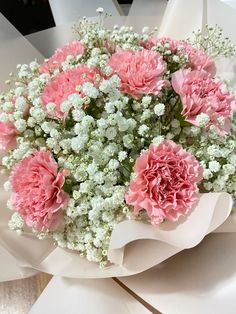 a bouquet of pink carnations and white baby's breath