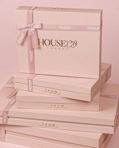 four boxes stacked on top of each other with pink ribbon around the edges and bows