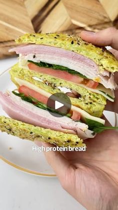 a person is holding a sandwich with ham and lettuce