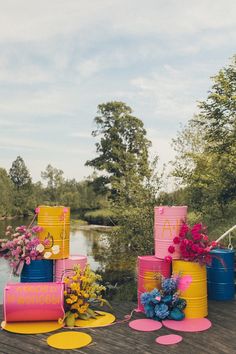 colorfully decorated birthday cakes sitting on top of a wooden deck next to flowers and trees