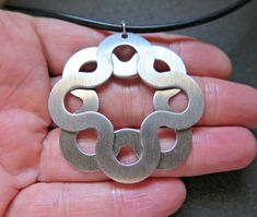 "I created this celtic knot necklace in a seamless black rubber necklace and stainless steel pendant. The necklace is 22 inches long and the pendant is 1 3/4\" wide and slightly longer with the stainless steel loop bail. This pendant is also considered an infinity design. The pendant is slightly domed and has a subtle brushed finish. The back is shiny and tiny rivets can be seen. Because of the design, the necklace can be worn to feature either side of the pendant. This necklace will be shipped in a splurge gift tin. Additional modern artisan jewelry can be found in my shop here: http://www.etsy.com/shop/Splurge?ref=si_shop" Rubber Necklace, Celtic Knot Necklace, Thick Necklace, Infinity Design, Tin Gifts, Square Bead, Necklace Black, Knot Necklace, Men's Necklace