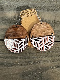 two wooden earrings with laser cut designs on them