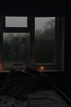 a bed sitting next to a window in a dark room