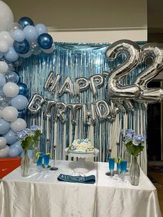 a birthday party with balloons and streamers in the shape of two numbers on a table