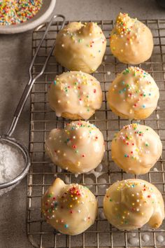 several donuts with sprinkles on a cooling rack