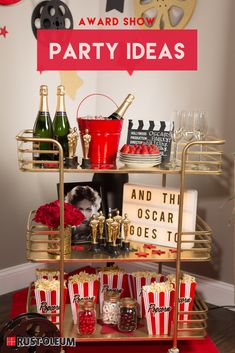 a red and gold party cart with popcorn, wine glasses, snacks and movie tickets