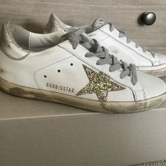 Super Star Classic Golden Goose Sneaker. Gold Star And Silver Back. In Excellent Condition Only Worn A Few Times. Size 35. Box And Dust Bag Included. Shoes Golden Goose, Goose Shoes, Golden Goose Shoes, Super Star, Gold Star, Golden Goose, Gold Stars, Golden Goose Sneaker, White Silver