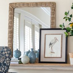 a mirror sitting on top of a mantle next to vases