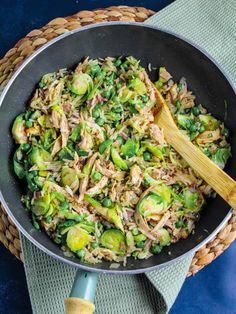 brussels sprouts and chicken in a skillet with a wooden spoon