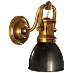 an antique brass wall light with black shade