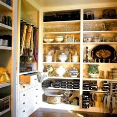 an organized pantry with lots of items on the shelves and dishes in bowls, pans, etc