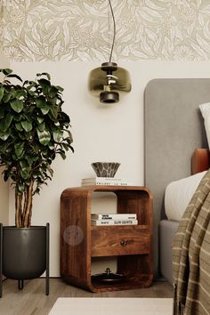 a bed room with a plant and a nightstand